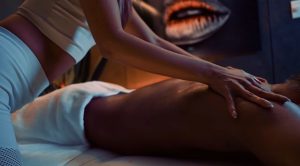 Close-up of a seated woman’s legs in soft indoor lighting.