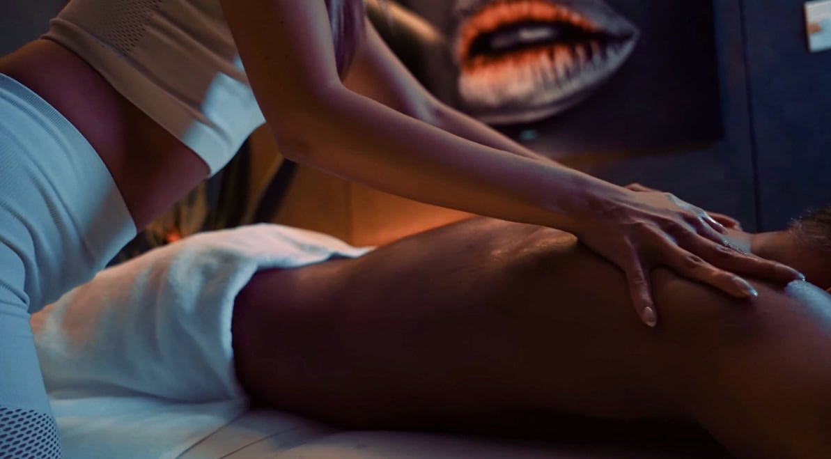Close-up of a seated woman’s legs in soft indoor lighting.